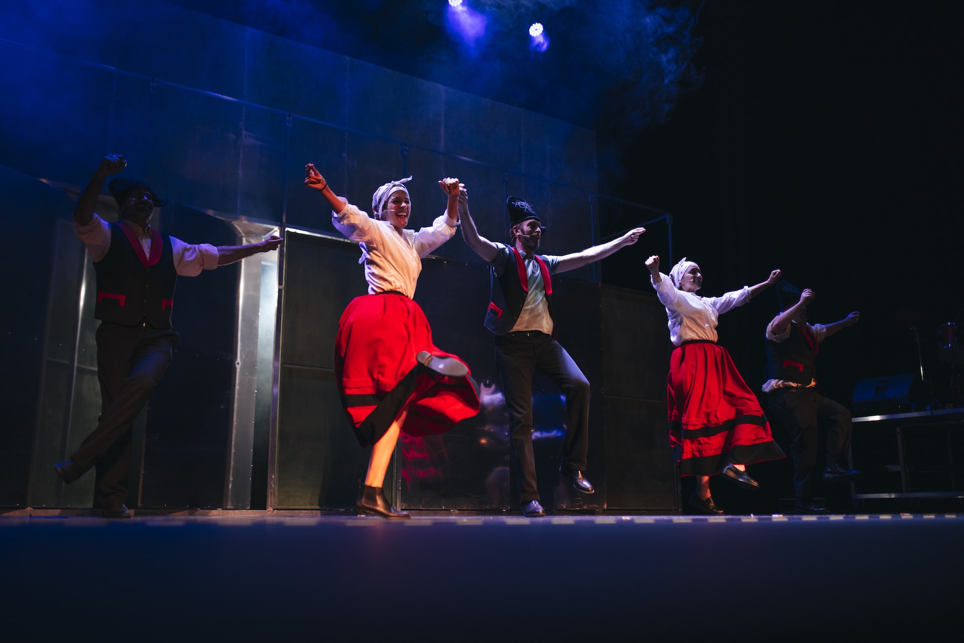 Los actores del espectáculo teatral Fariña bailando con trajes gallegos